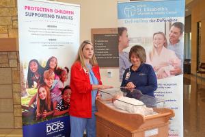 St. Elizabeth's nurses demonstrating how to safely put a baby to sleep. 